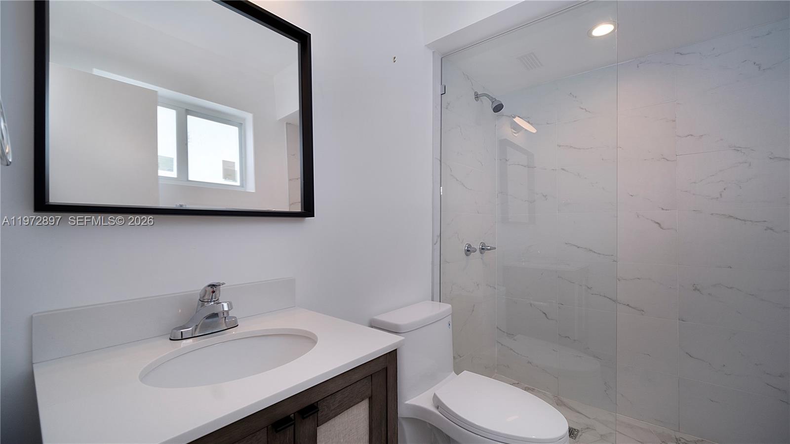 11690 Southwest 81st Road, Unit 11690 Pinecrest, FL 33156 - Photo 18 of 26 a bathroom with a sink mirror and toilet