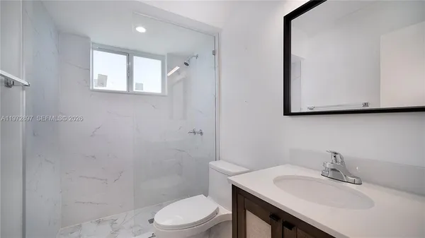 a bathroom with a sink a toilet and mirror