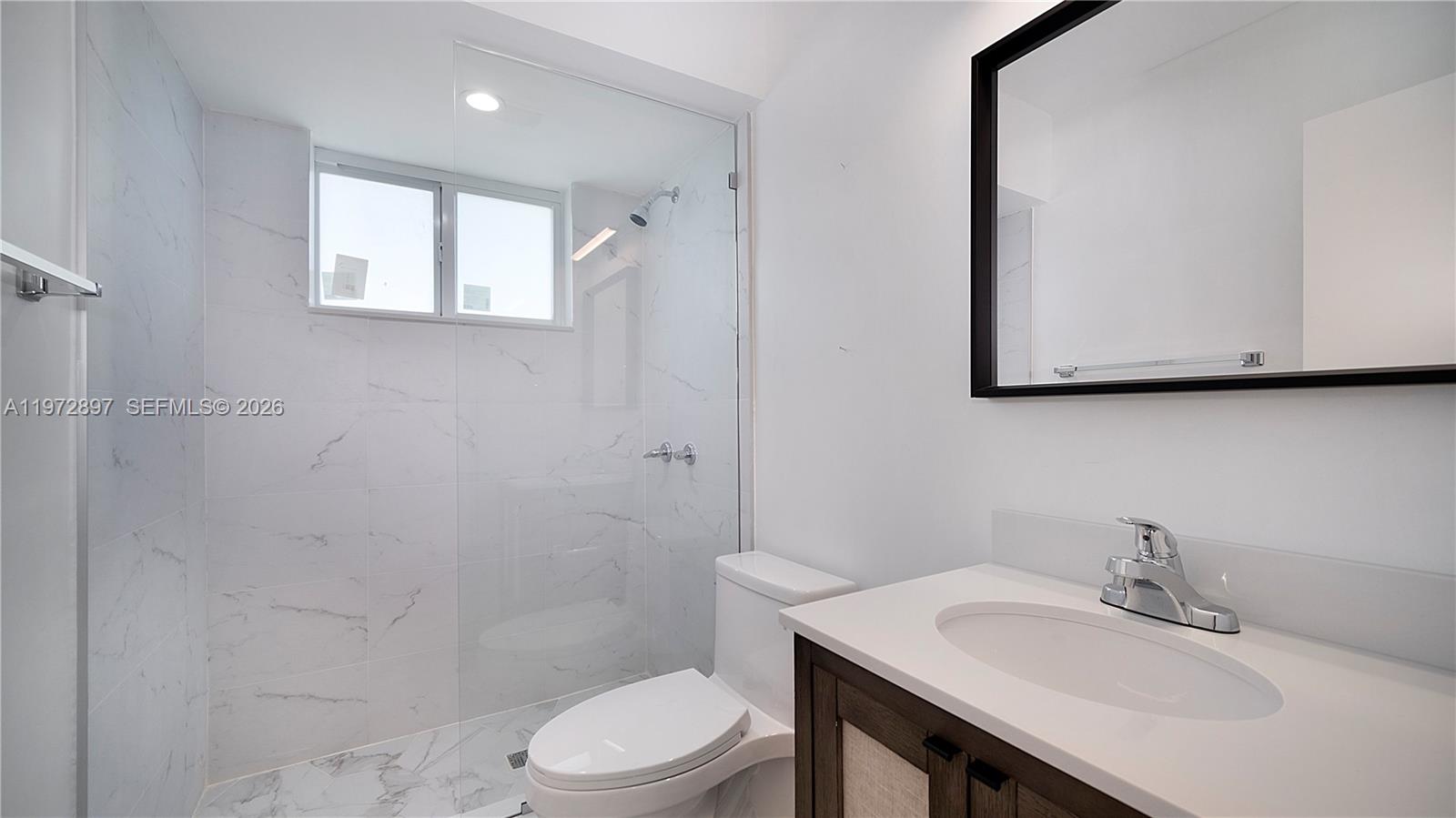 11690 Southwest 81st Road, Unit 11690 Pinecrest, FL 33156 - Photo 20 of 26 a bathroom with a sink a toilet and mirror