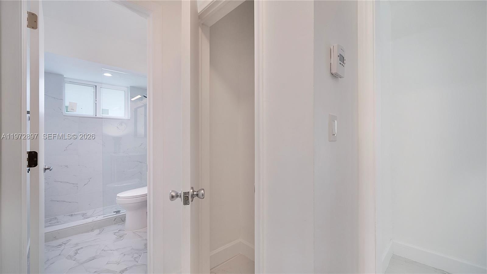 11690 Southwest 81st Road, Unit 11690 Pinecrest, FL 33156 - Photo 25 of 26 a bathroom with a granite countertop shower and a toilet