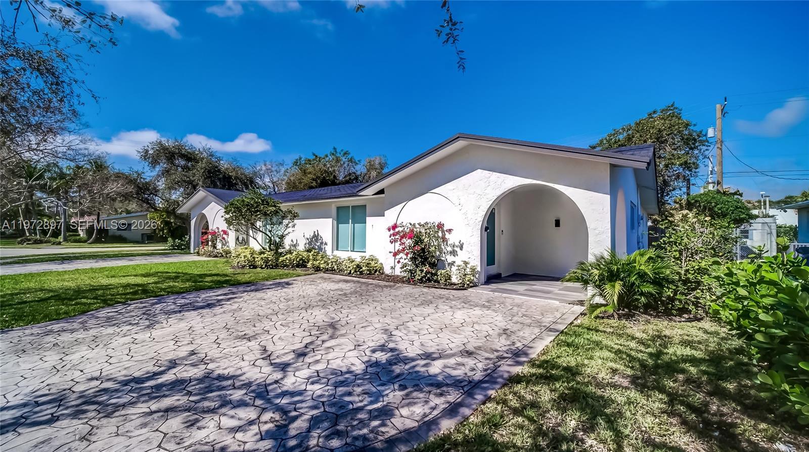 11690 Southwest 81st Road, Unit 11690 Pinecrest, FL 33156 - Photo 3 of 26 a front view of a house with a yard and garage