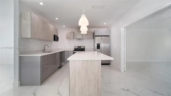 a kitchen with kitchen island a sink stainless steel appliances and cabinets