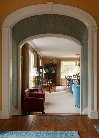 a living room with a large mirror and a potted plant