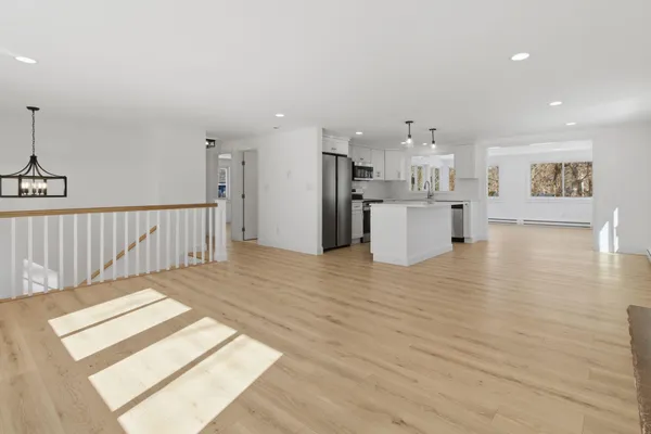 a view of empty room with wooden floor and windows