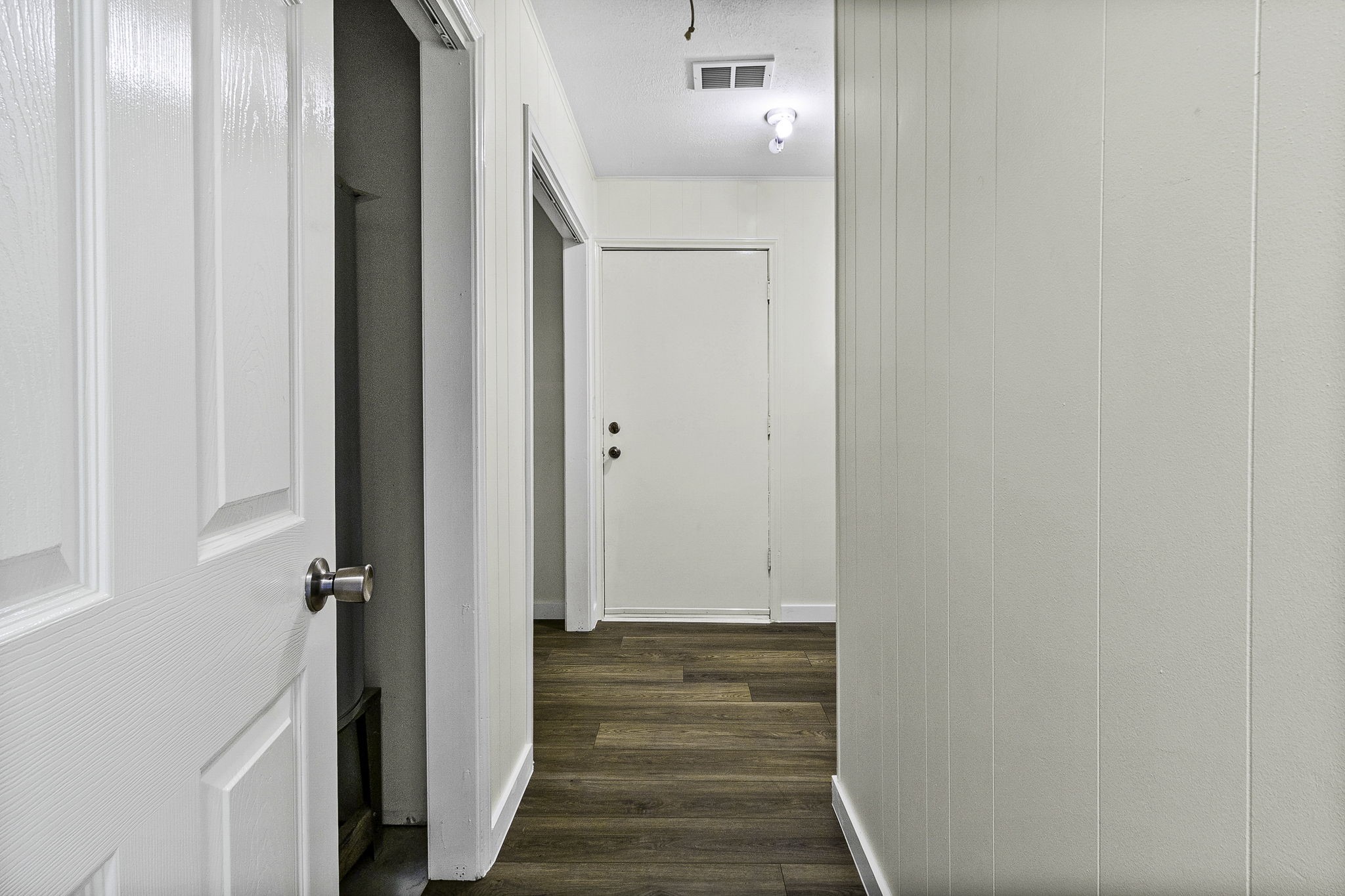 51 Rustling Oaks Coldspring, TX 77331 - Photo 26 of 43 Hallway leading to additional storage and laundry room. Door straight ahead leads to oversized 2-car garage.