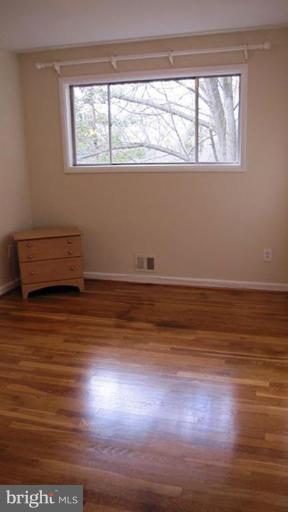 6115 Greentree Road Bethesda, MD 20817 - Photo 16 of 19 a room with wooden floor and windows