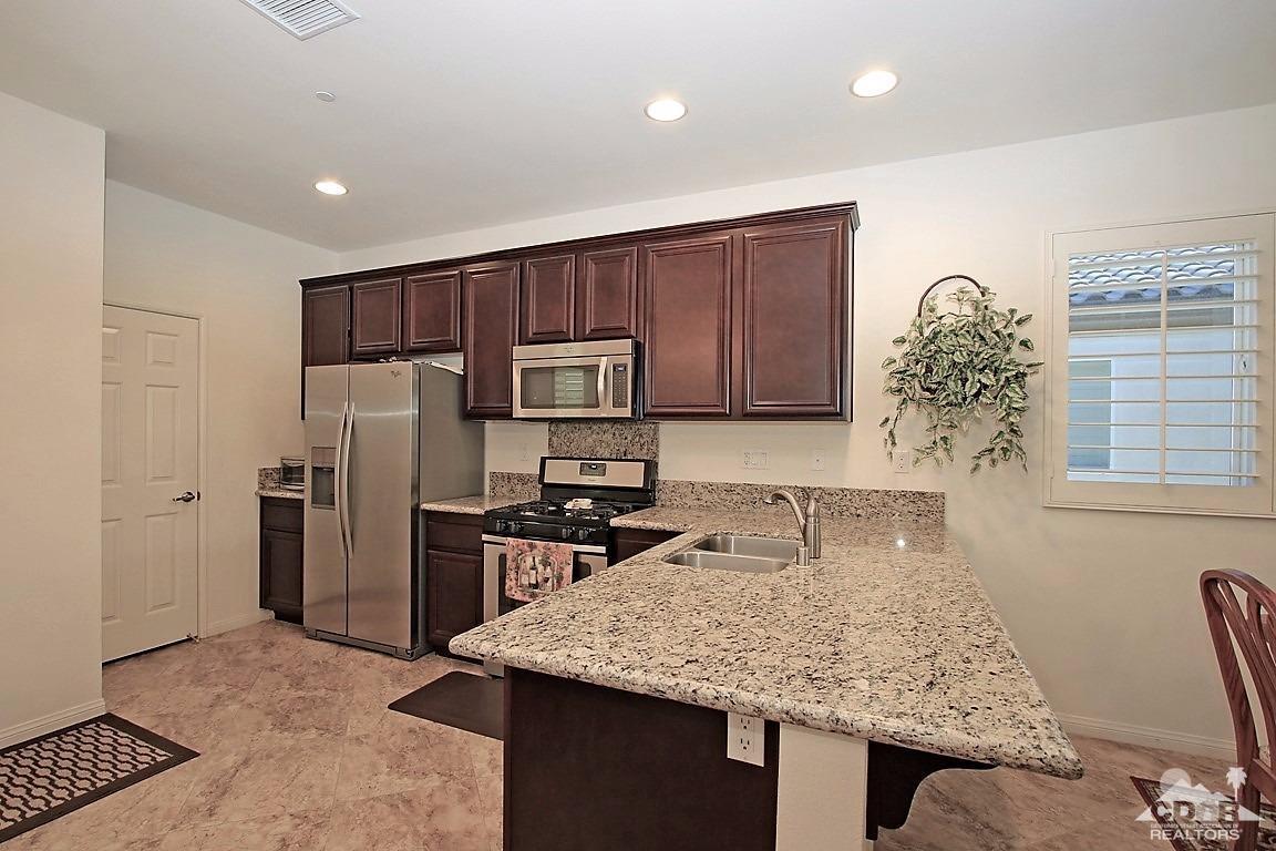 49818 Minelli Street Indio, CA 92201 - Photo 4 of 30 a kitchen with stainless steel appliances granite countertop a sink stove and refrigerator