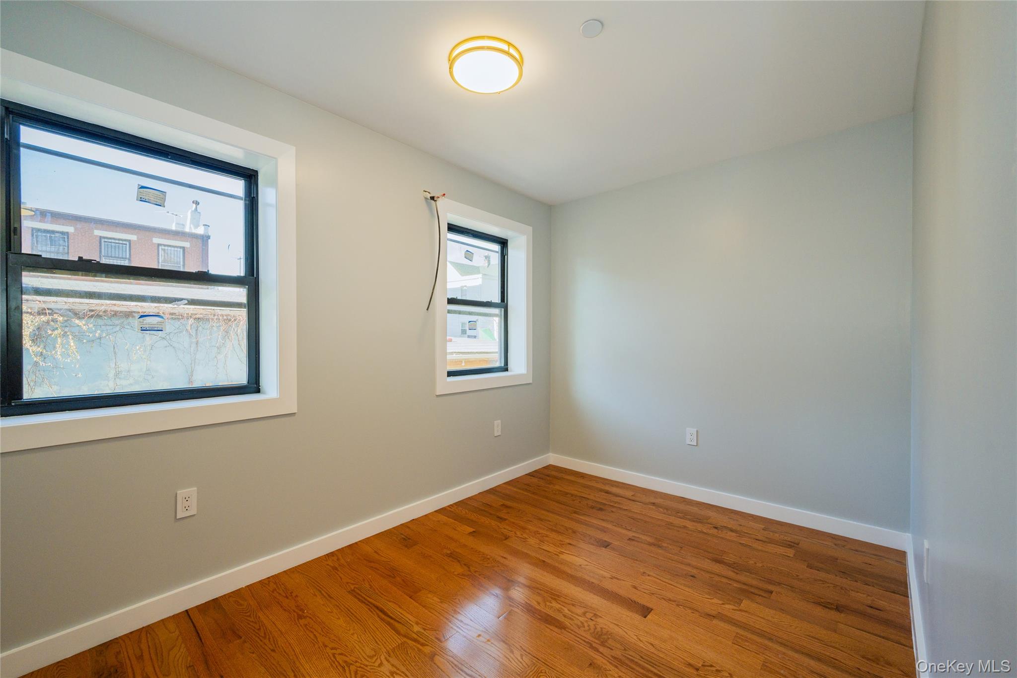 33-34 109th Street Queens, NY 11368 - Photo 18 of 26 a view of empty room with window and wooden floor