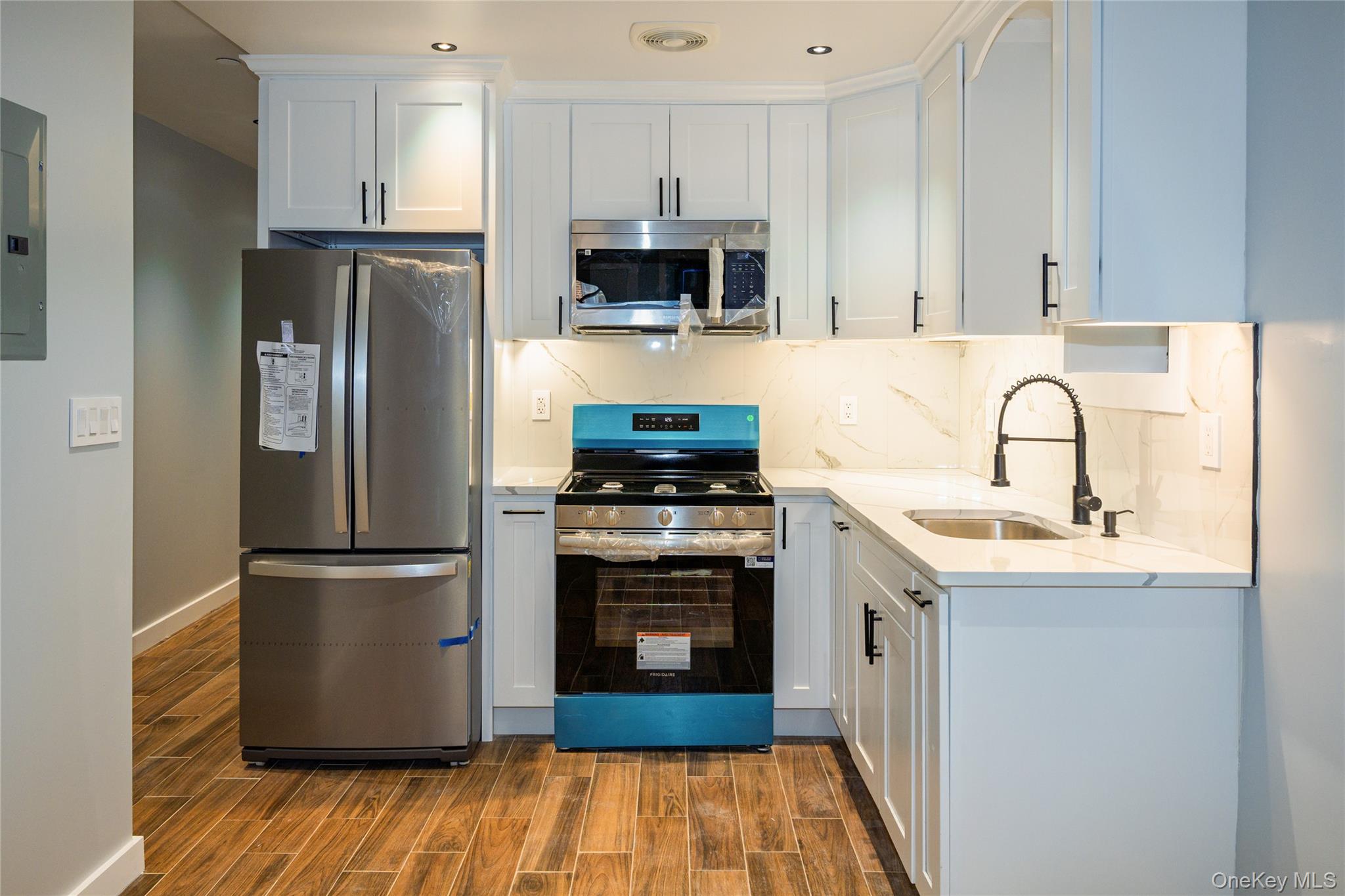 33-34 109th Street Queens, NY 11368 - Photo 8 of 26 a kitchen with stainless steel appliances granite countertop a refrigerator stove and sink