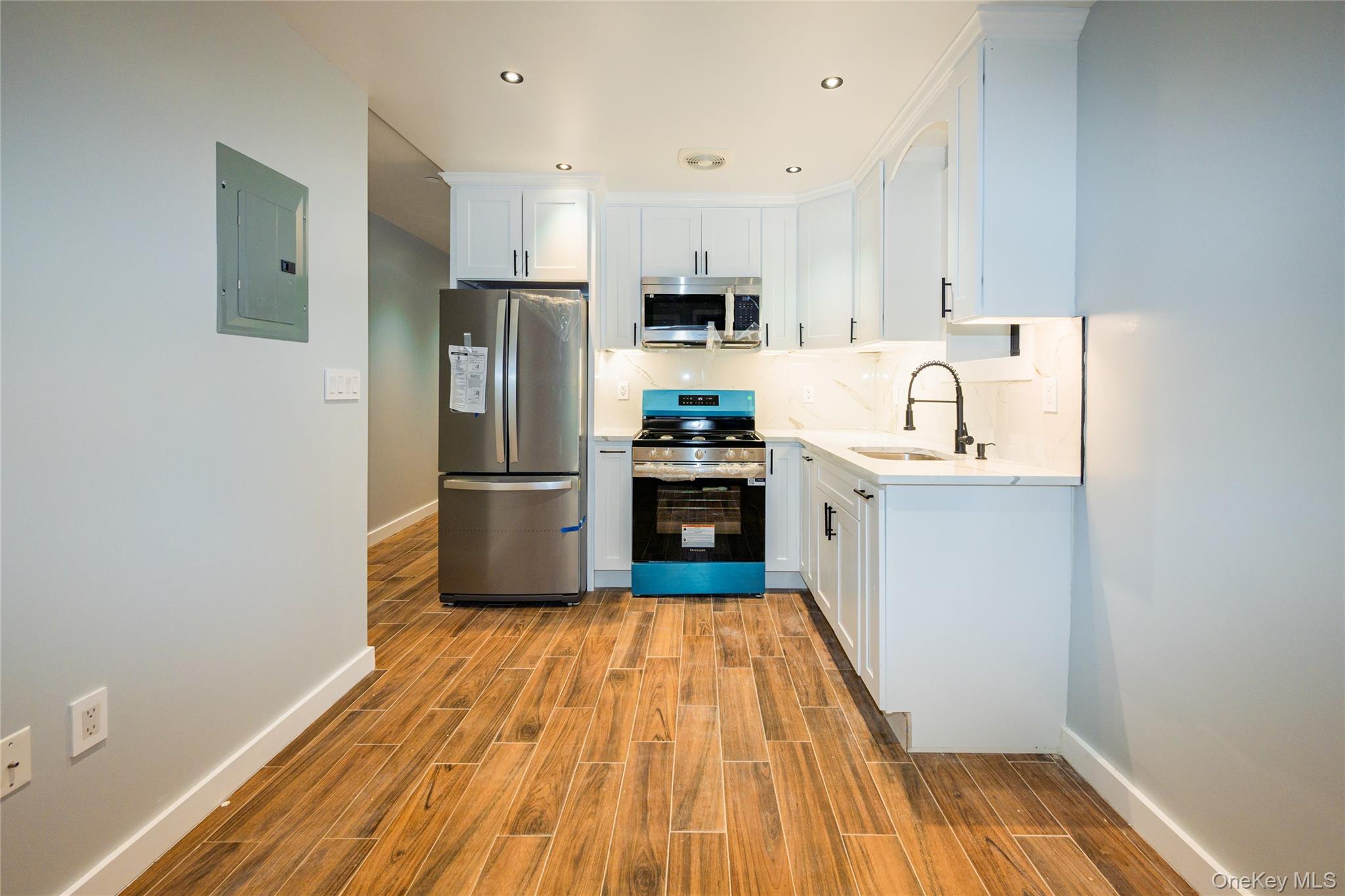 33-34 109th Street Queens, NY 11368 - Photo 9 of 26 a kitchen with granite countertop a refrigerator and a sink
