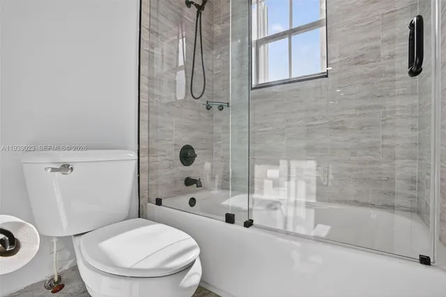 an empty room with white walls and ceiling fan