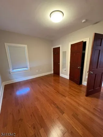 an empty room with wooden floor and closet