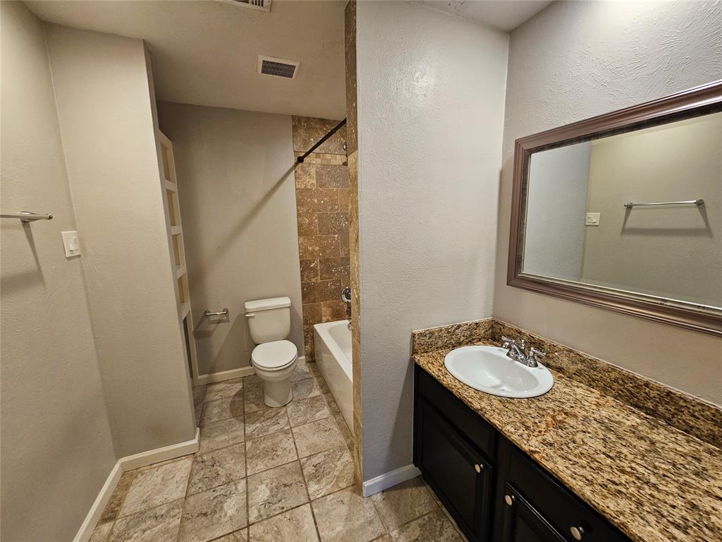 8601 Park Lane, Unit 522 Dallas, TX 75231 - Photo 12 of 21 a bathroom with a granite countertop sink a toilet and shower