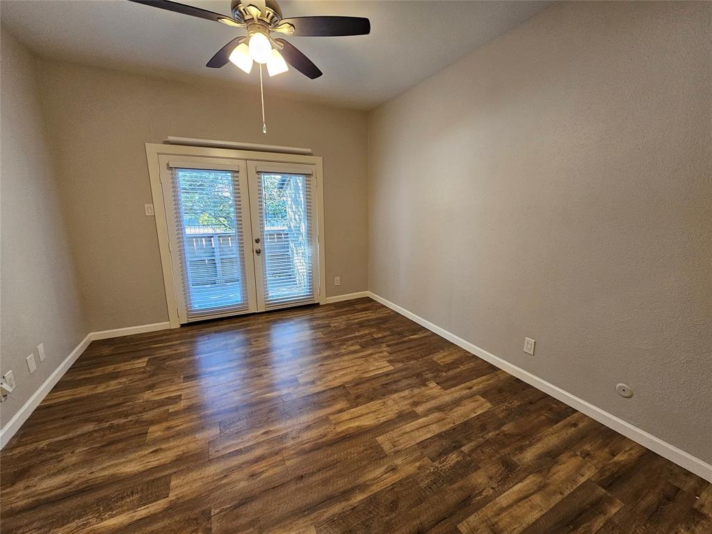 8601 Park Lane, Unit 522 Dallas, TX 75231 - Photo 15 of 21 an empty room with wooden floor chandelier fan and windows