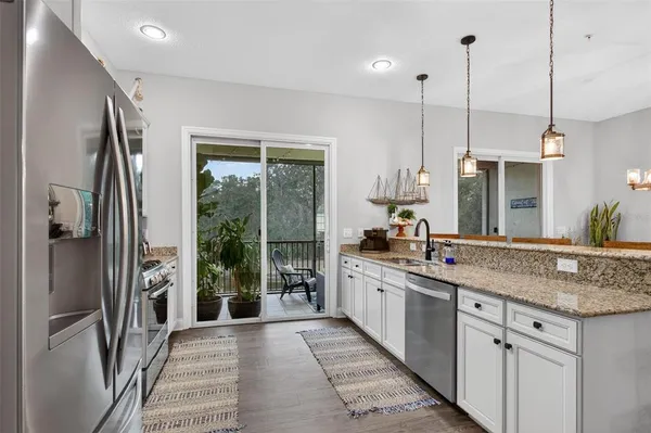 a kitchen with stainless steel appliances granite countertop a refrigerator a sink and a stove