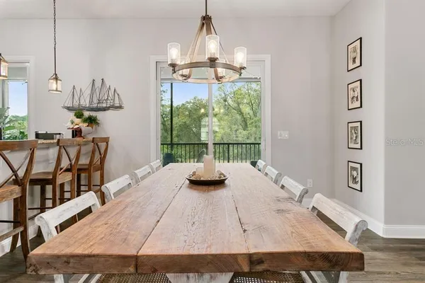 a view of a dining room with furniture a chandelier and wooden floor