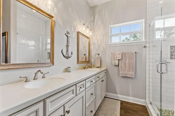 a bathroom with a double vanity sink a mirror and shower