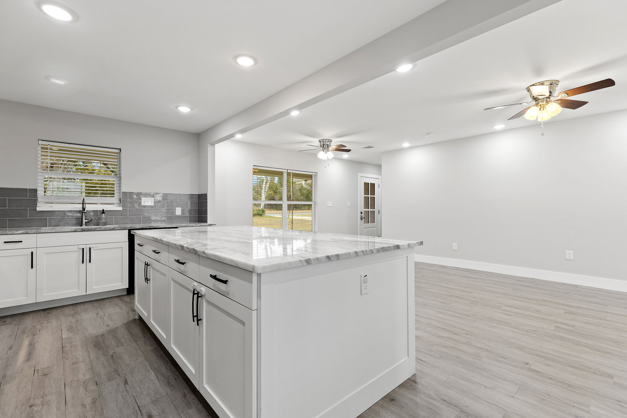 813 Central Avenue Elgin, TX 78621 - Photo 7 of 22 Kitchen with a kitchen island, recessed lighting, light stone countertops, white cabinets, and plenty of natural light
