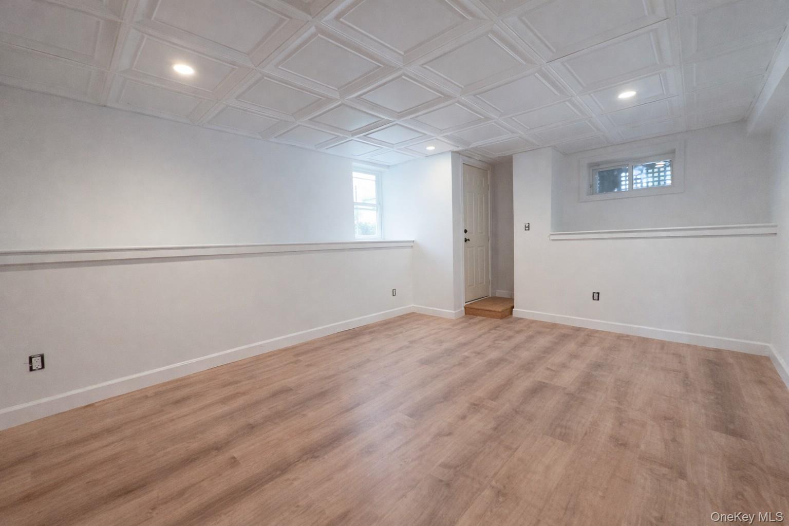 1009 Hudson Avenue, Unit 1S Peekskill, NY 10566 - Photo 18 of 21 an empty room with wooden floor and windows