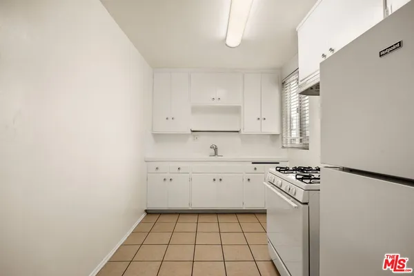 a kitchen with white cabinets and white appliances