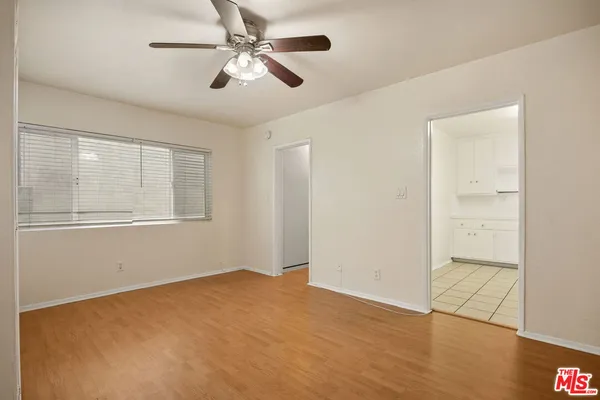 an empty room with a window and a fan