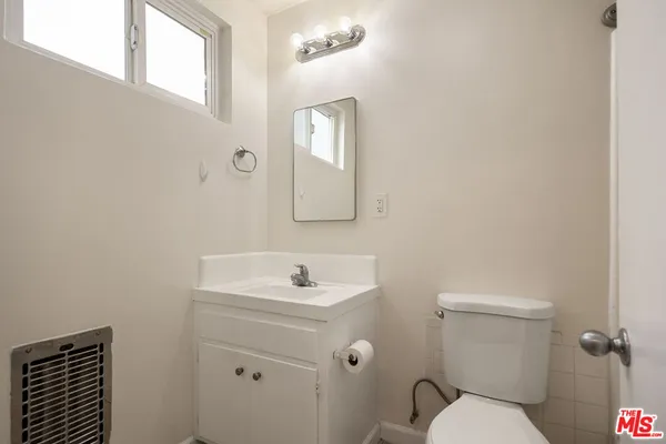 a kitchen with granite countertop a stove a sink and white cabinets