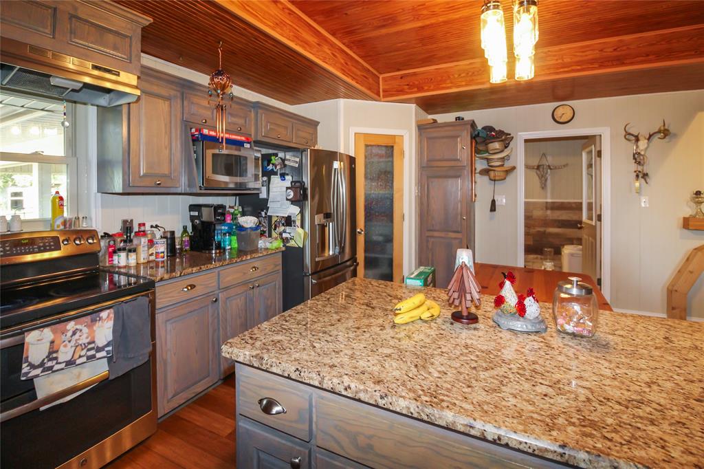 1001 Sandy Ridge Road Scurry, TX 75158 - Photo 19 of 35 Kitchen featuring a wood plank ceiling, recessed lighting, granite countertops, stainless steel appliances, and gray-toned cabinetry