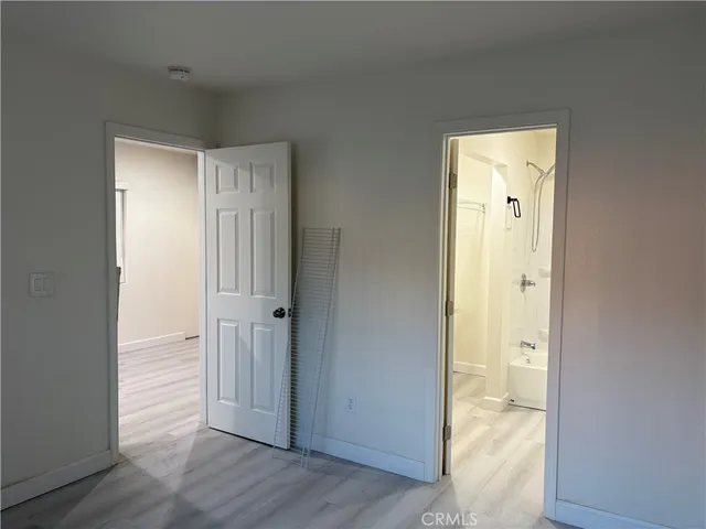 an empty room with wooden floor & mirror