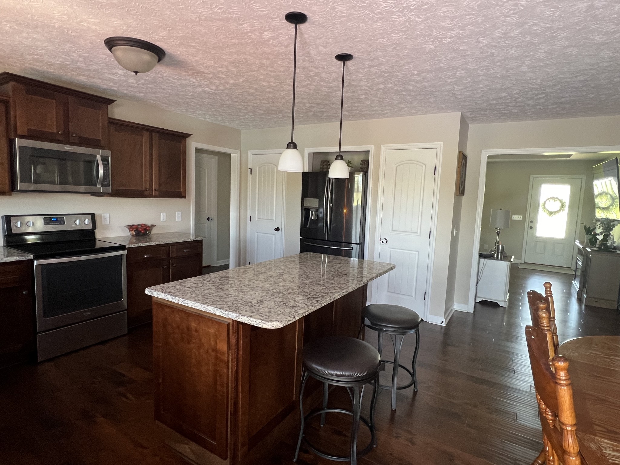 546 Corinth Road Portland, TN 37148 - Photo 18 of 37 a kitchen with stainless steel appliances granite countertop a kitchen island a stove a table and chairs