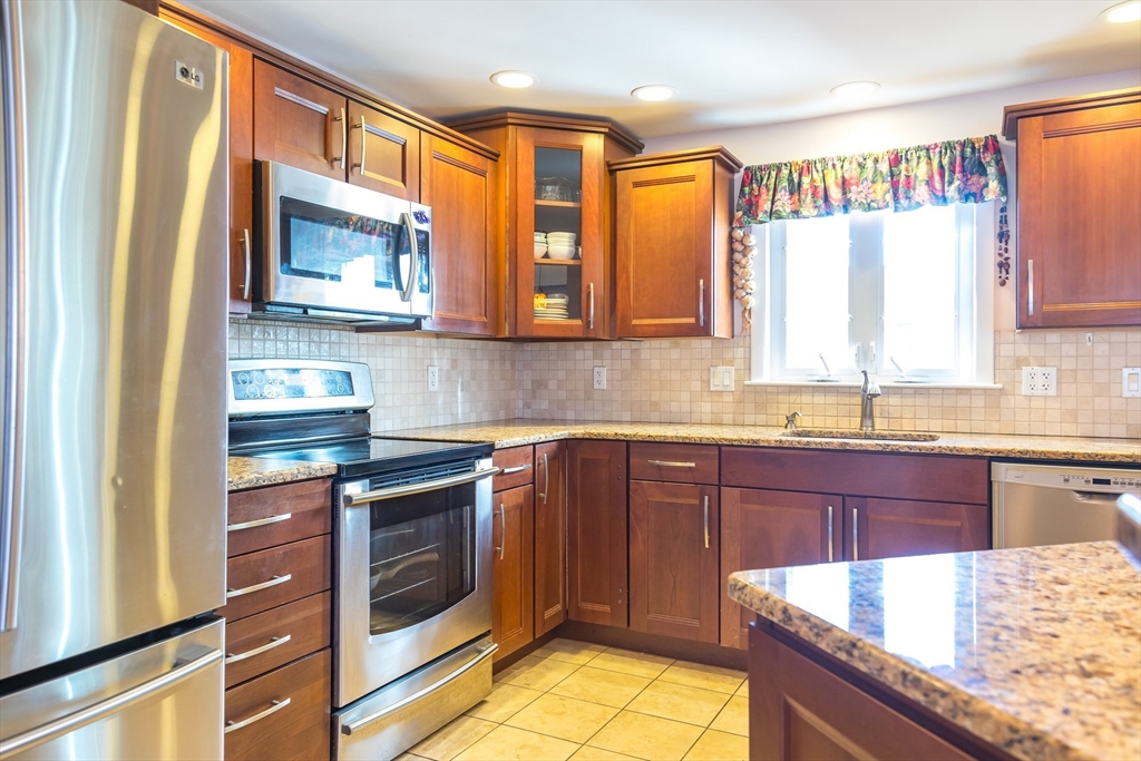15 Higgins Road Marblehead, MA 01945 - Photo 4 of 26 a kitchen with stainless steel appliances granite countertop a stove a sink and a microwave