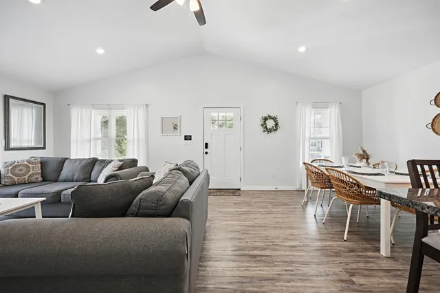 a living room with furniture a window and wooden floor
