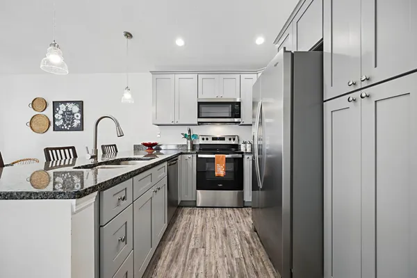 a kitchen with granite countertop a refrigerator stove and sink