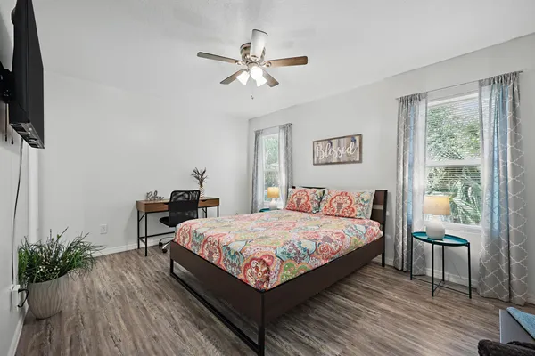 a bed room with a bed window and a flat screen tv