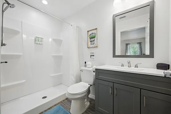 a bathroom with a sink a toilet and shower