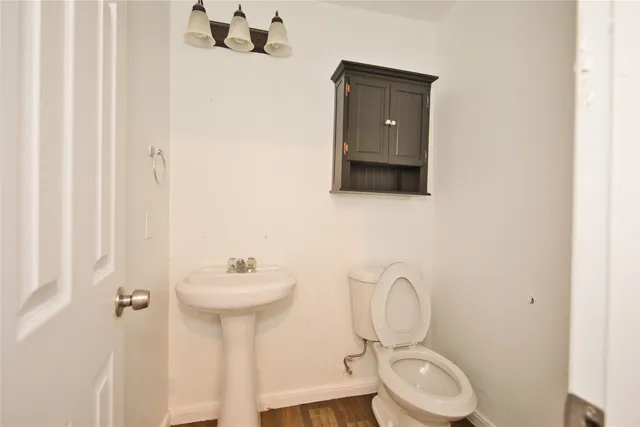 a bathroom with a toilet sink and mirror