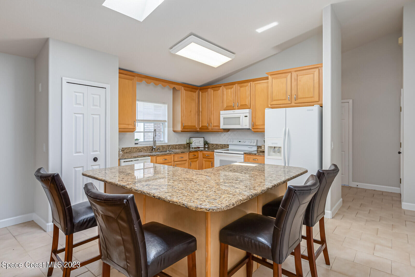 1041 South Fork Circle Melbourne, FL 32901 - Photo 9 of 62 a dining room with granite countertop a table chairs and a refrigerator