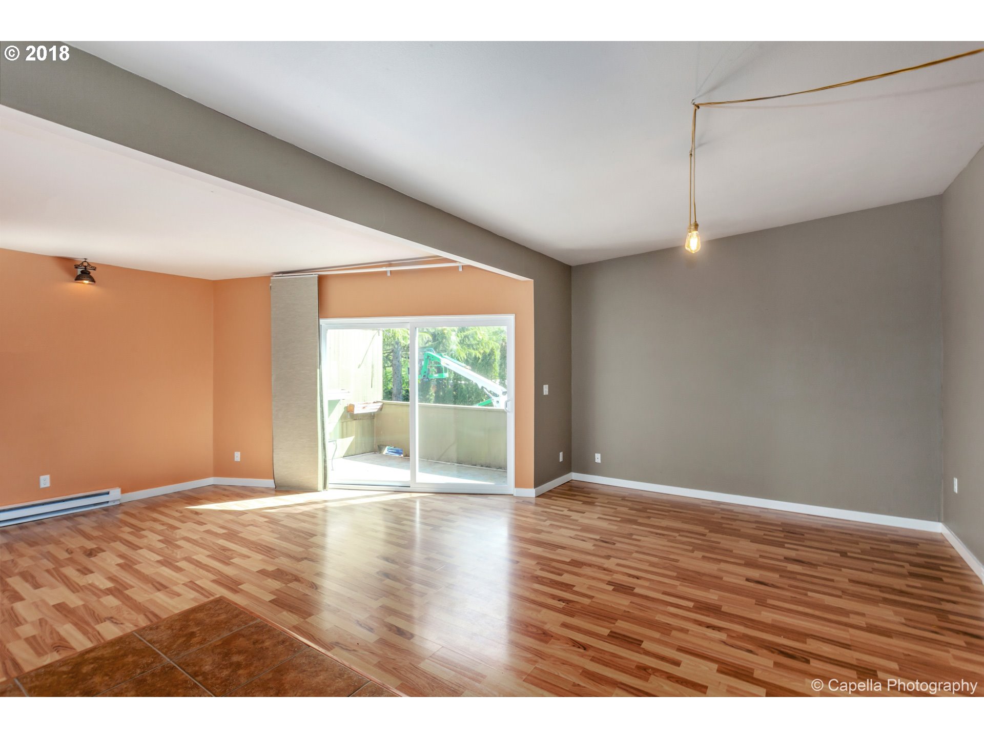 6220 Southwest Capitol Highway, Unit 8 Portland, OR 97239 - Photo 7 of 13 a view of an empty room with wooden floor and a window