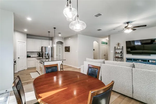 a view of kitchen with sink microwave refrigerator dining table and chairs