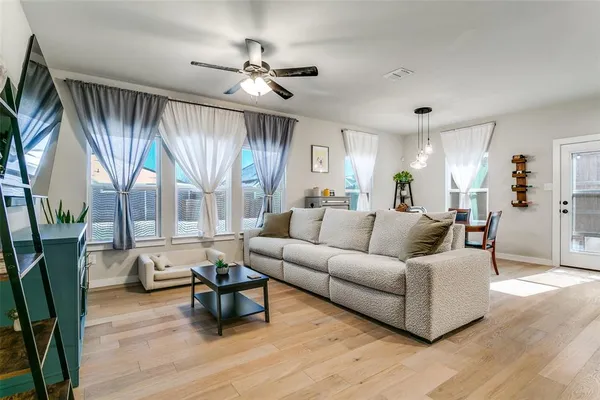 a living room with furniture and a wooden floor