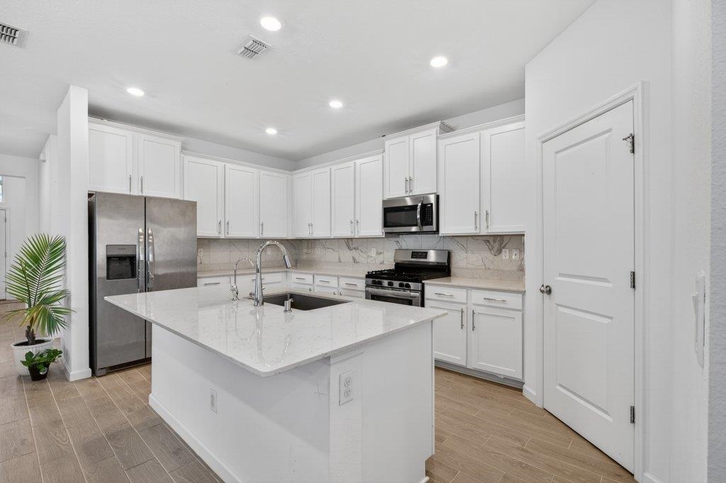 210 White Rabbit Run St. Augustine, FL 32092 - Photo 30 of 85 a kitchen that has a lot of white cabinets and stainless steel appliances