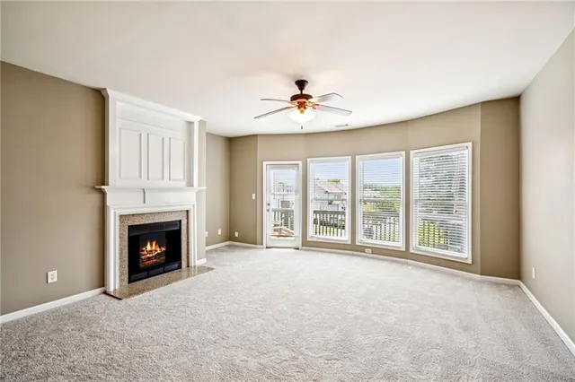 a view of an empty room with a fireplace and a window