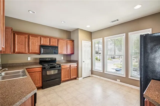 a kitchen with stainless steel appliances granite countertop a refrigerator and a sink