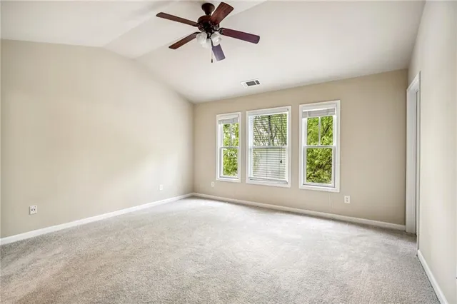 a view of a big room with a ceiling fan and windows