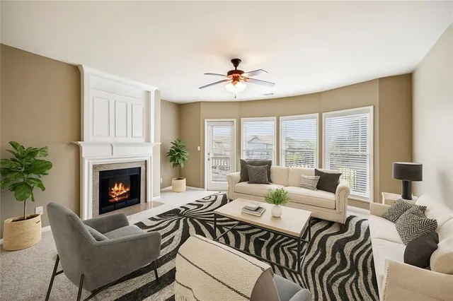 a living room with furniture a fireplace and a large window
