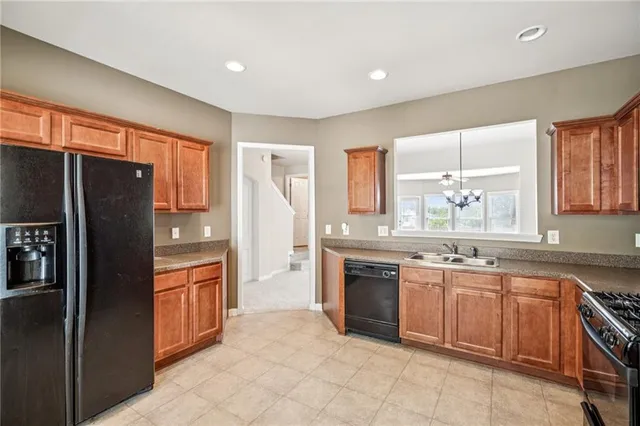 a kitchen with stainless steel appliances granite countertop a refrigerator and a sink