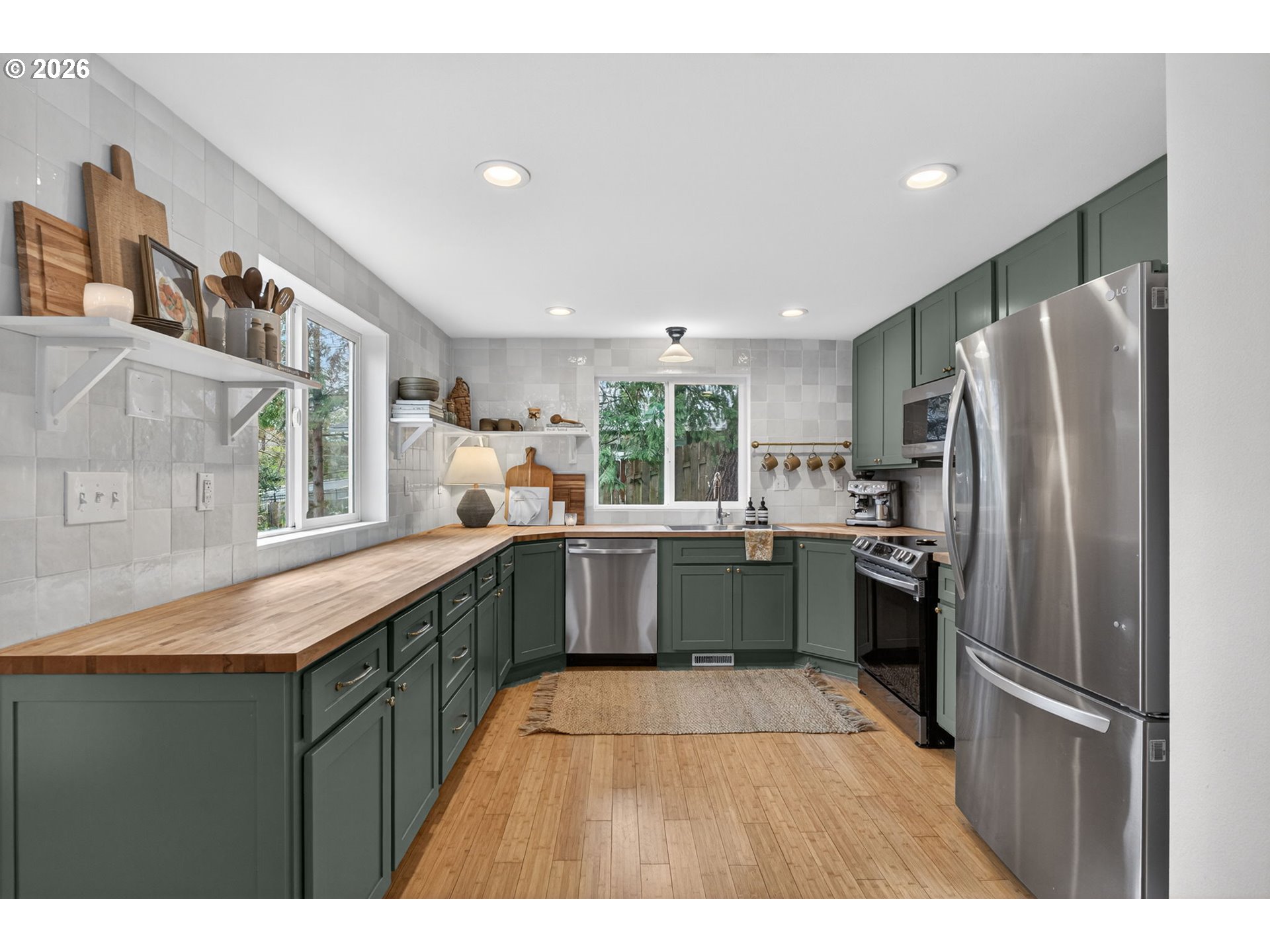 9843 Southwest 2nd Avenue Portland, OR 97219 - Photo 11 of 38 a kitchen with stainless steel appliances granite countertop a refrigerator a sink dishwasher a stove with wooden cabinets