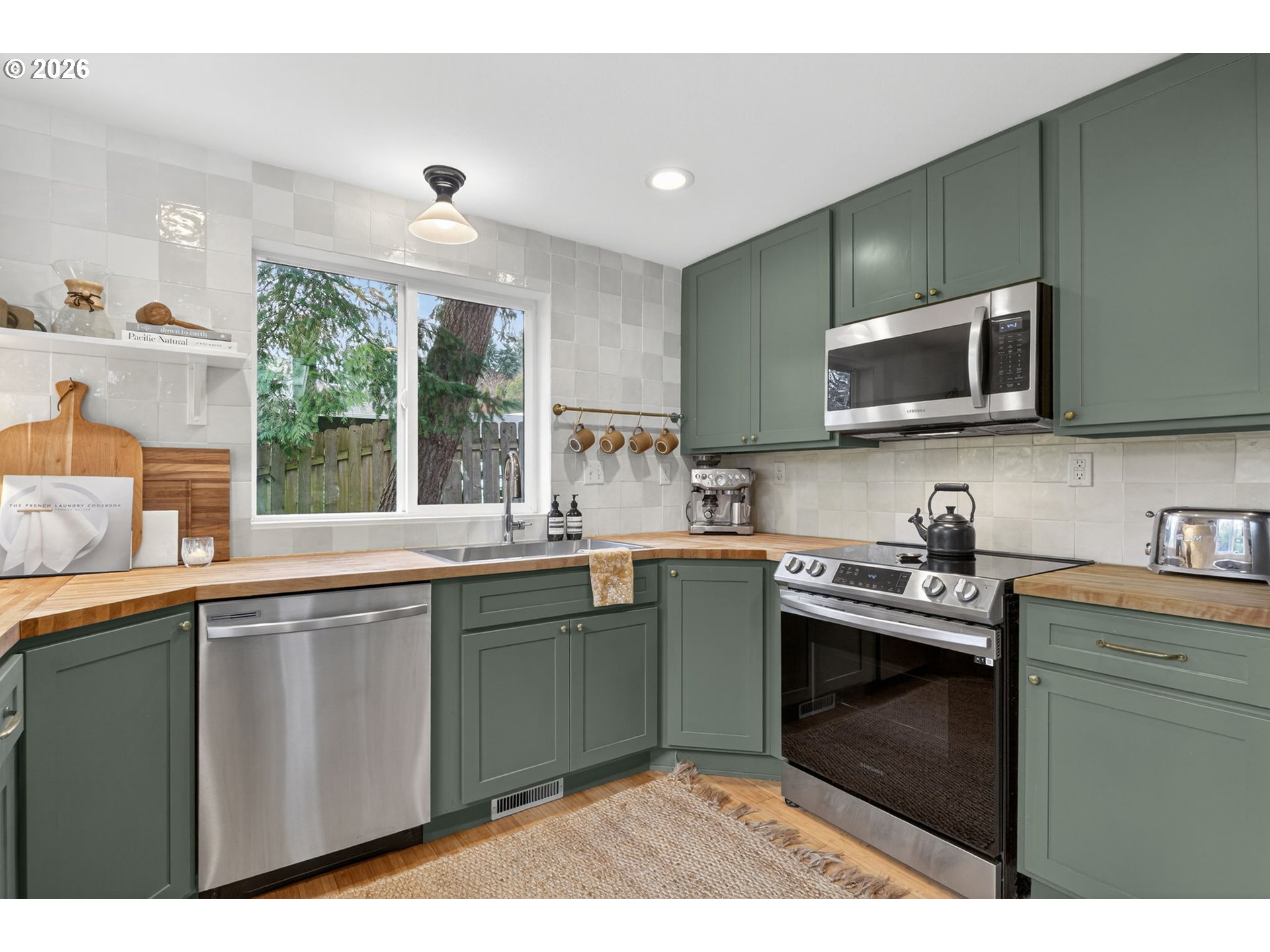 9843 Southwest 2nd Avenue Portland, OR 97219 - Photo 14 of 38 a kitchen with stainless steel appliances kitchen island granite countertop a sink and cabinets