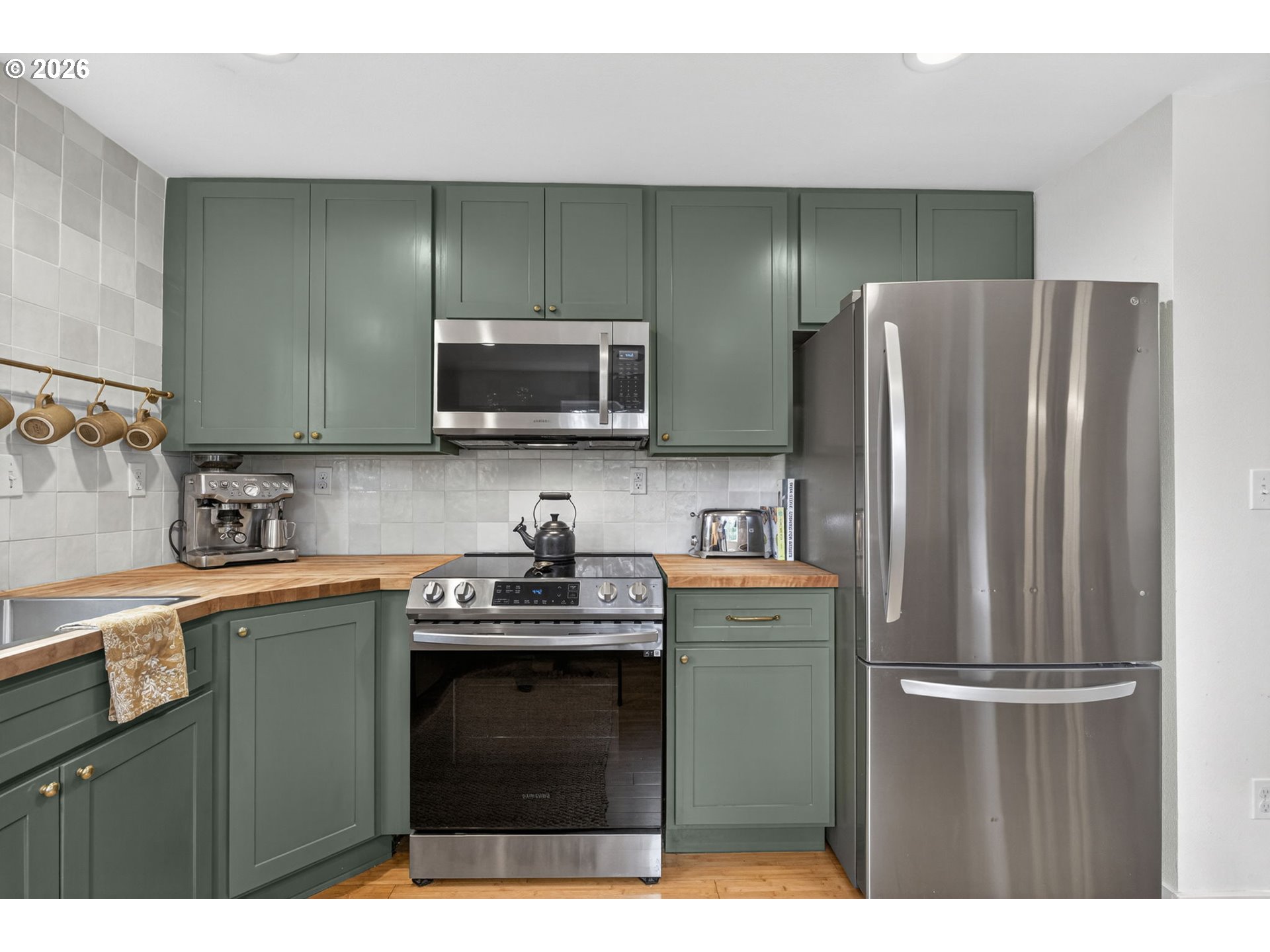 9843 Southwest 2nd Avenue Portland, OR 97219 - Photo 15 of 38 a kitchen with stainless steel appliances granite countertop a refrigerator stove top oven and sink