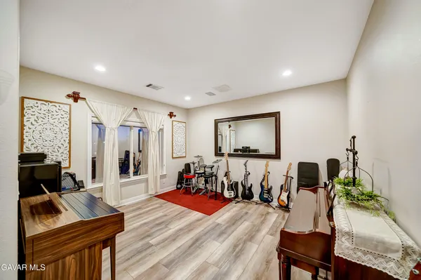 a large white kitchen with granite countertop a stove a sink a dining table and chairs with wooden floor