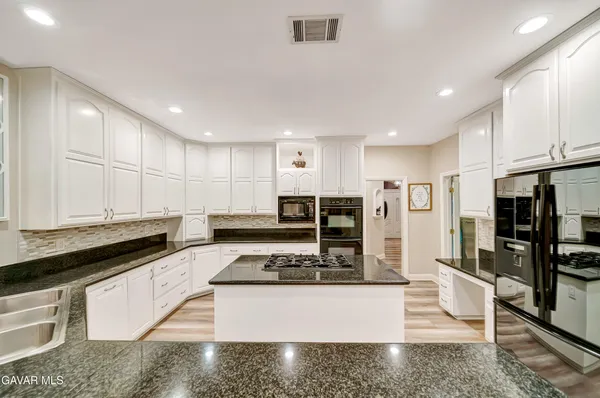 a bathroom with a granite countertop sink a toilet and a bathtub